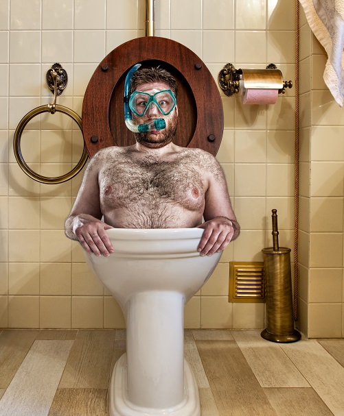 Bizarre man with goggles swimming in vintage toilet